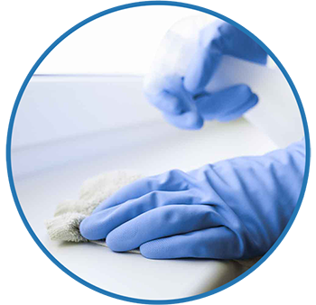 Manos con guantes limpian meticulosamente una superficie 